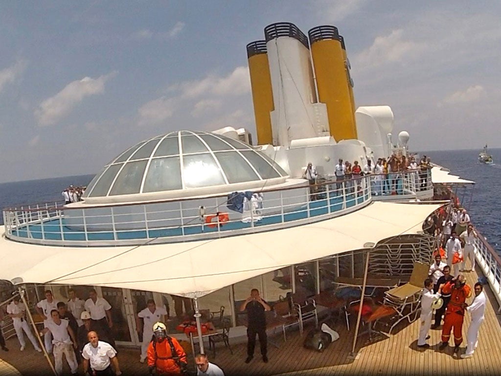 Passengers and crew take shelter on the deck of the Costa Allegra