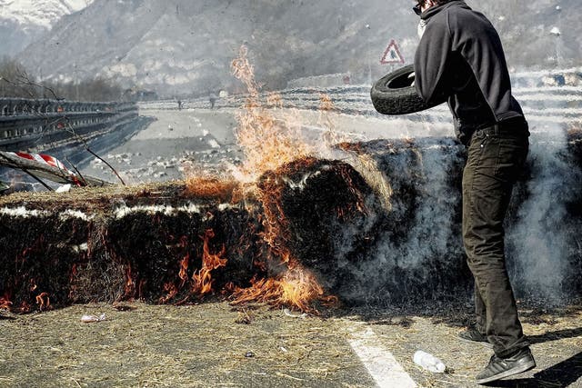 An activist set fire to tyres during a protest last week against the rail tunnel in northern Italy