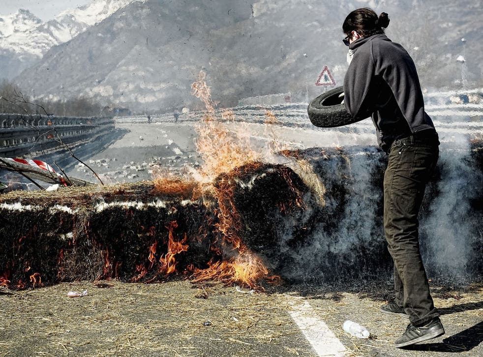 An activist set fire to tyres during a protest last week against the rail tunnel in northern Italy