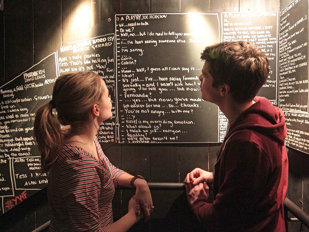 Punters peruse some of the public's 100-word plays on the walls at the Royal Court Theatre.