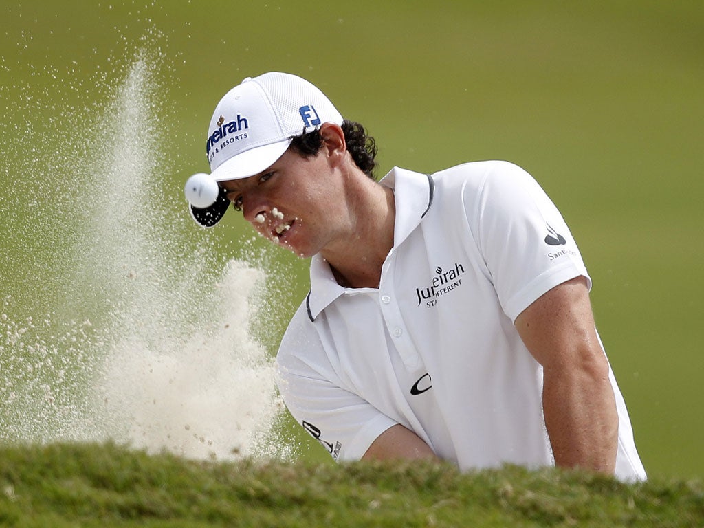 Rory McIlroy hits from a bunker on the 10th during his difficult start yesterday