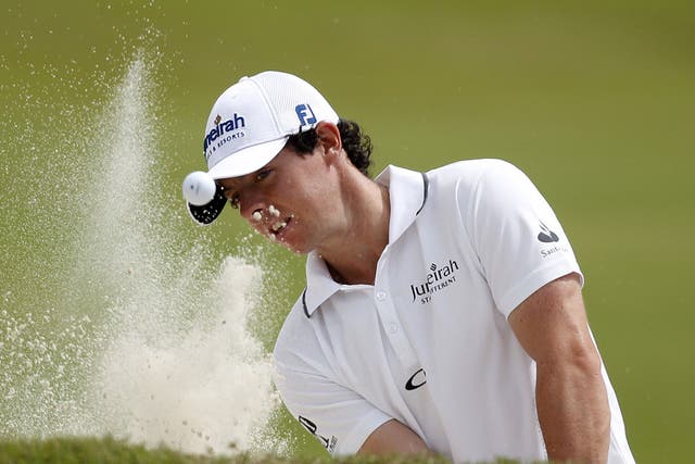 Rory McIlroy hits from a bunker on the 10th during his difficult start yesterday