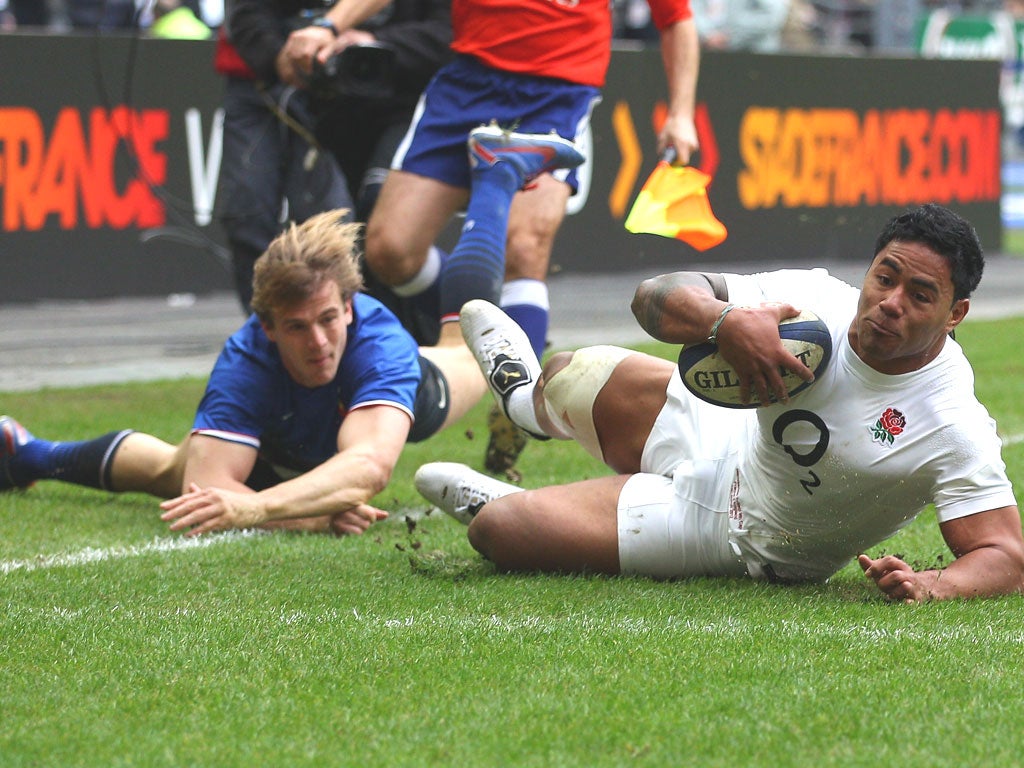 Manu Tuilagi slides in to score for England despite the efforts of France’s Aurélien Rougerie at the Stade de France yesterday