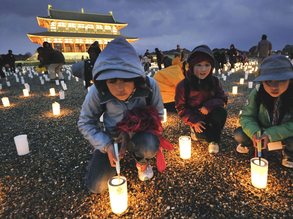 Children light candles during a service near Heijo Palace in Nara, central Japan