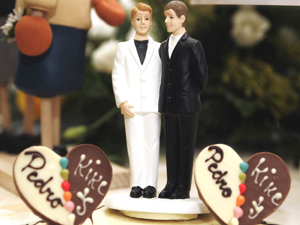 A wedding cake figurine of a same-sex couple made up of two men