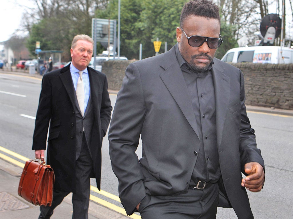Dereck Chisora arrives at a British Boxing Board of Control hearing in Cardiff with promoter Frank Warren (left)