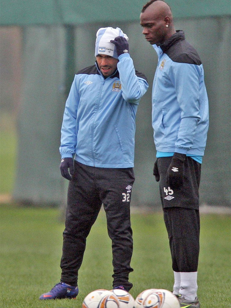 Manchester City's Carlos Tevez (left) and his team-mate Mario Balotelli during a training session at Carrington yesterday