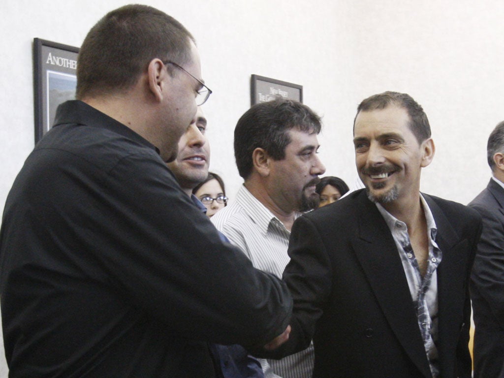 Plaintiffs Candido Silva Jnr and Carlos Fernandes shake hands after winning their court case against Americo Lopes