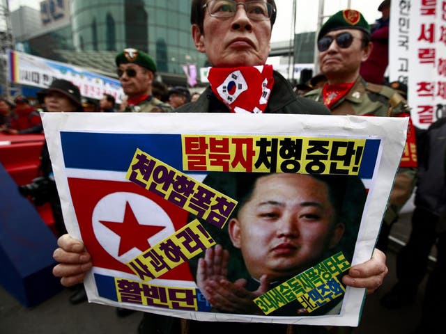 A South Korean war veteran holds a picture of the North’s new leader Kim Jong-Un at a protest in Seoul yesterday