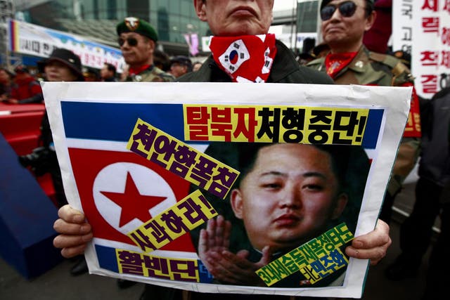 A South Korean war veteran holds a picture of the North’s new leader Kim Jong-Un at a protest in Seoul yesterday