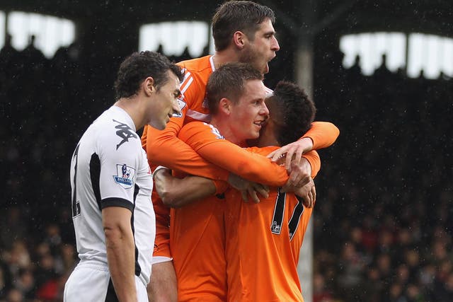 Flying Swans: Midfielder Gylfi Sigurdsson is swamped by Swansea team-mates after scoring the first of his two goals against Fulham at Craven Cottage