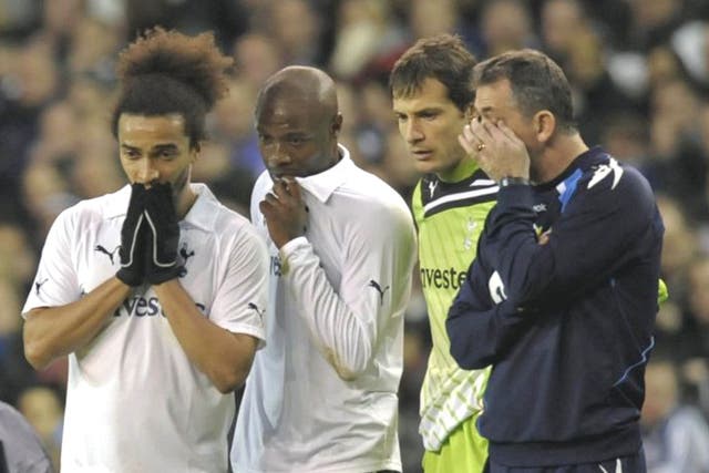 The Bolton manager, Owen Coyle (right), stands beside Spurs players Benoit Assou-Ekotto, William Gallas and Carlo Cudicini as Fabrice
Muamba is treated by medical staff at White Hart Lane
