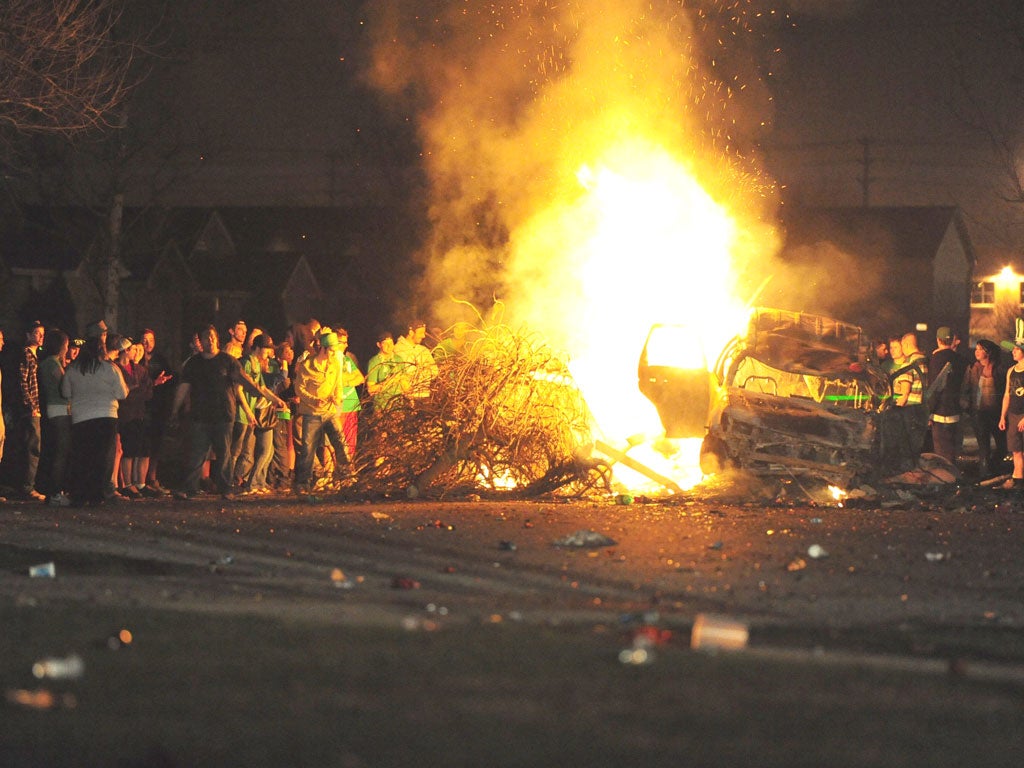 Young St Patrick’s Day revellers gather round the street blaze in London, Ontario