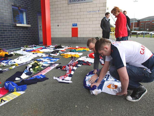 Fans lay a tribute to Fabrice Muamba outside the Reebok Stadium in Bolton yesterday