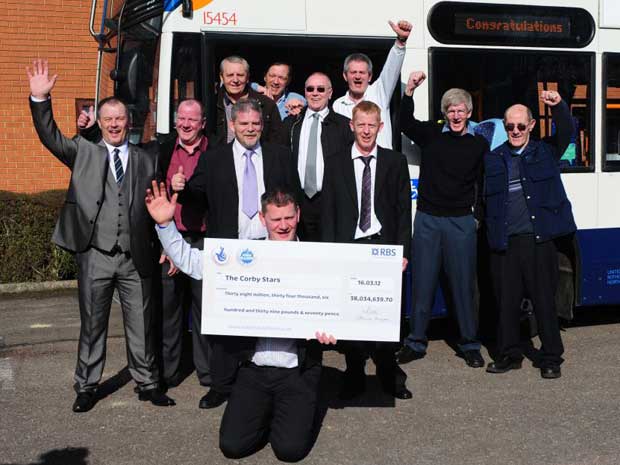 The syndicate of bus drivers from Corby celebrate after winning £38m. Chris Smith with cheque and (front left to right) Derek Wilson, Stephen Derrick, Charlie Gillion, and (back left to right), Derek Wilson, Dave Mead, Jim Patton, Ally Spence, Alex Robertson, Charlie Connor and Neil Tayton