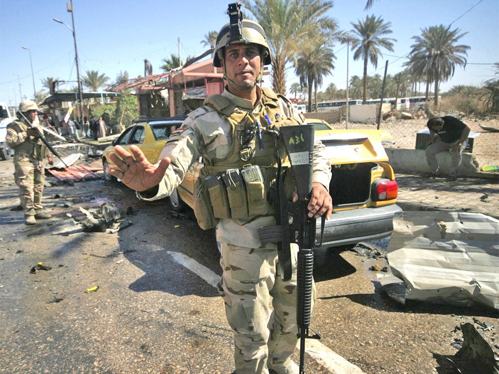 Security forces stand guard at the site of the bomb attack in Kerbala