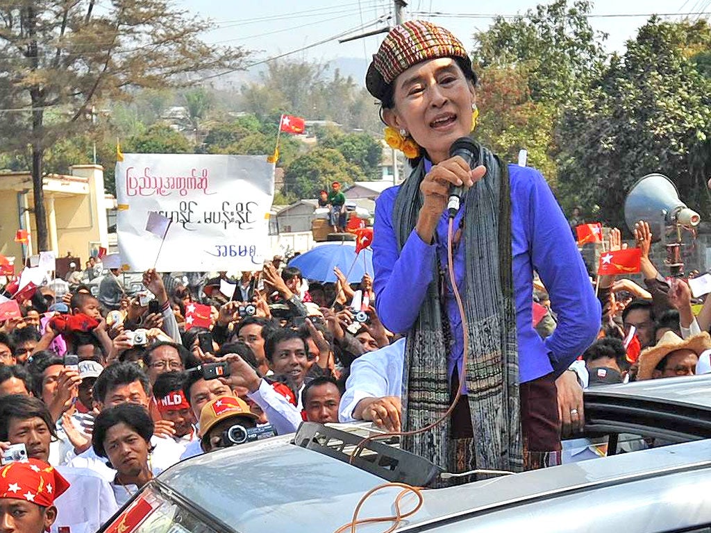 Aung San Suu Kyi talks to supporters during an election rally