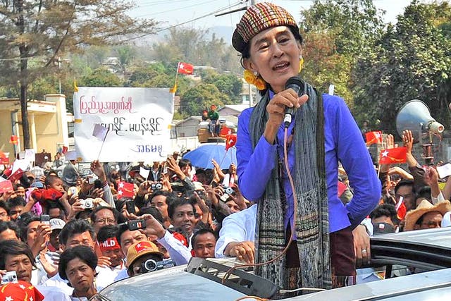 Aung San Suu Kyi talks to supporters during an election rally