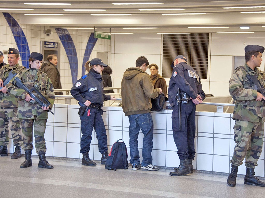 Soldiers and policemen check a passenger in a Toulouse subway station