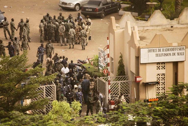 Malian soldiers and security forces gather at the offices of the state radio and television broadcaster after announcing a coup d'etat