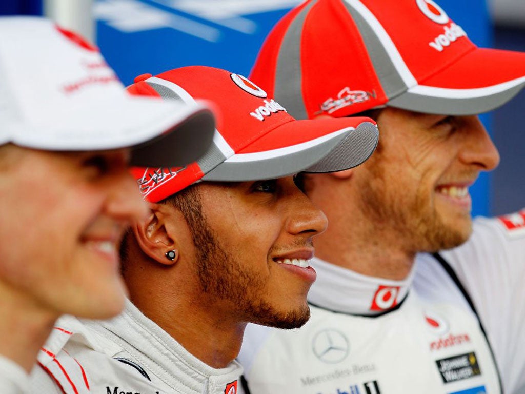 Third placed Michael Schumacher, pole sitter Lewis Hamilton and second placed Jenson Button celebrate following qualifying for the Malaysian Grand Prix