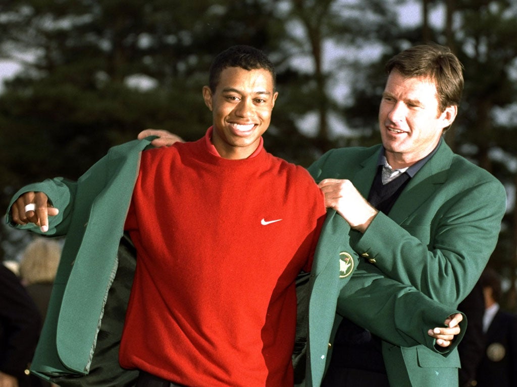 The 21-year-old Tiger Woods is helped into the Green Jacket by
Nick Faldo at the 1997 Masters after his first major win