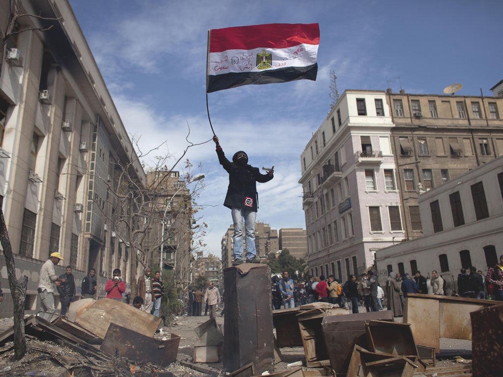 A protester waves an Egyptian flag staying during clashes between protesters and riot police in Cairo