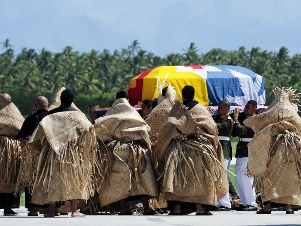 The casket carrying the body of King George Tupou V is draped in the Tongan royal standard upon its arrival at Fua'amotu International Airport
