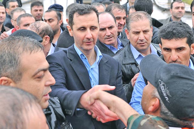 Syria's President Bashar al-Assad touring the devastated Baba Amr neighbourhood of Homs yesterday