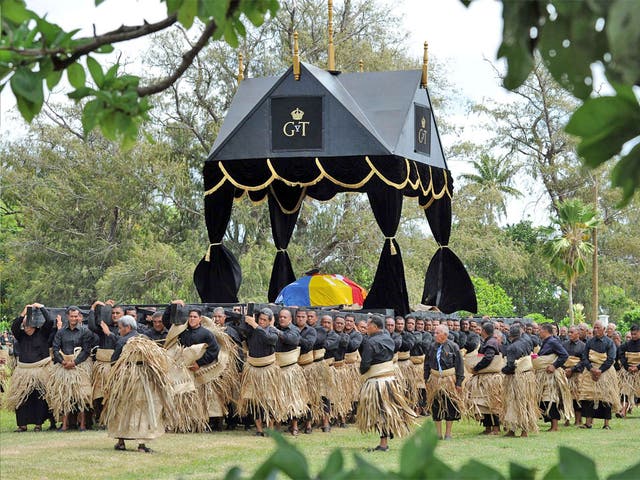 Hundreds of pall bearers, all wearing black clothes and traditional woven ta'ovala mats around their waists, carry the royal standard draped casket of King George Tupou V