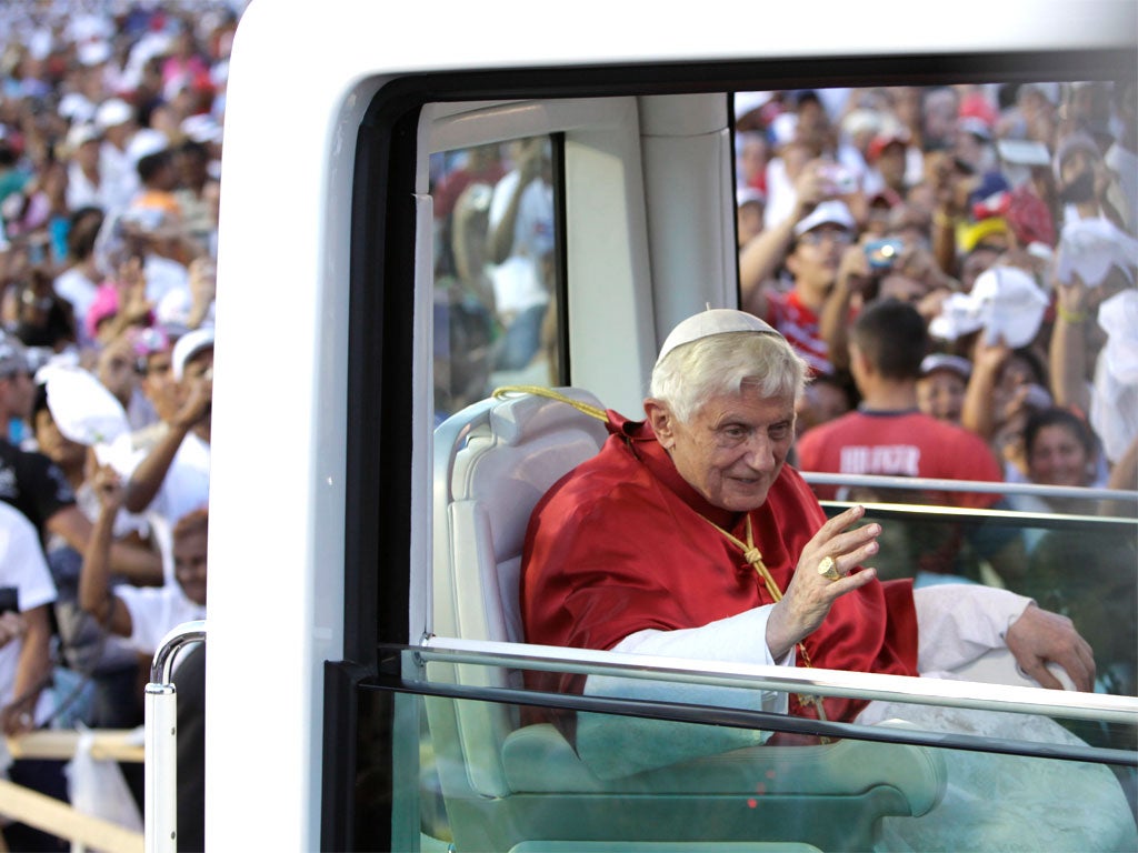 Pope Benedict XVI waves to faithful from his 'popemobile' as he arrives at Revolution Square