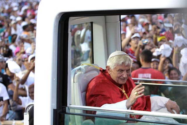 Pope Benedict XVI waves to faithful from his 'popemobile' as he arrives at Revolution Square