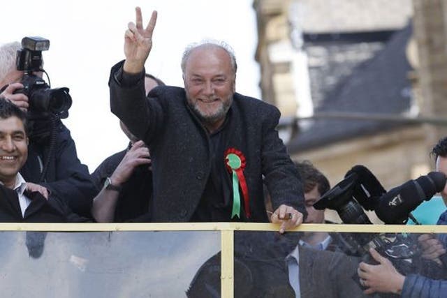 Respect Party candidate George Galloway gestures from a bus outside his campaign office in Bradford