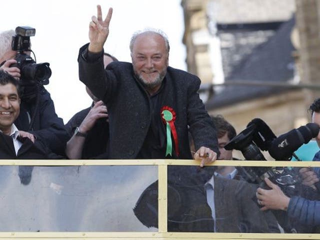 Respect Party candidate George Galloway gestures from a bus outside his campaign office in Bradford