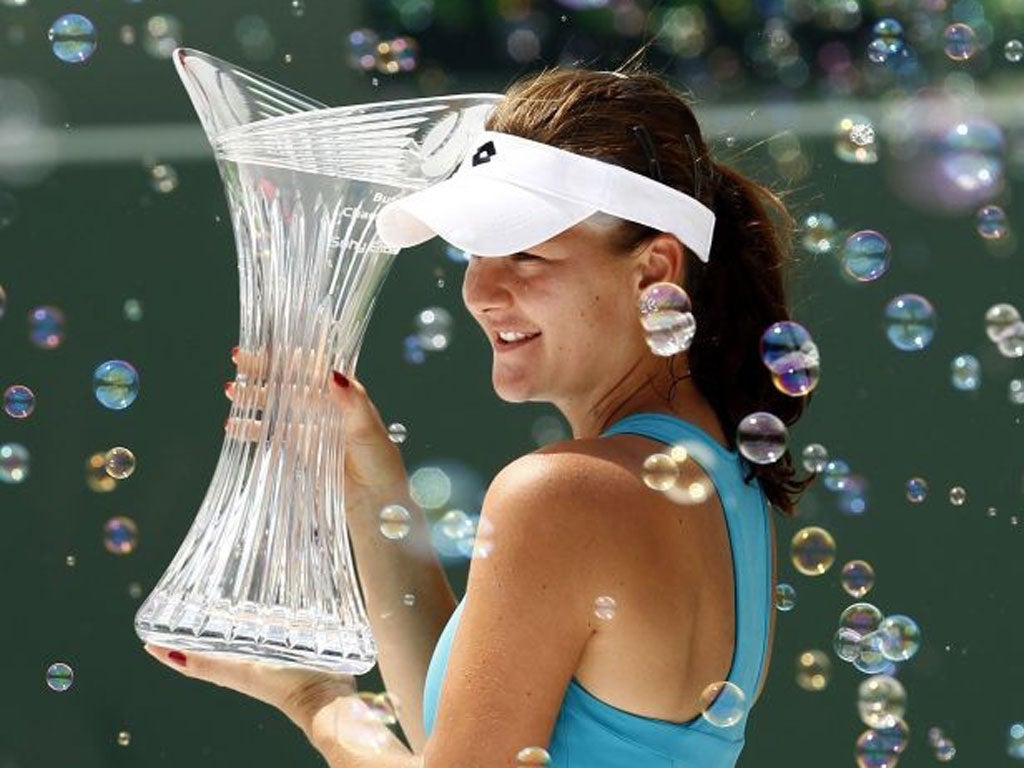 Agnieszka Radwanska displays the Sony Ericsson Open trophy after beating Maria Sharapova in the final