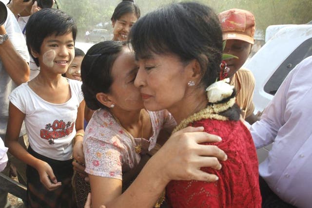 A voter embraces Aung San Suu Kyi at a polling station in Kawmhu