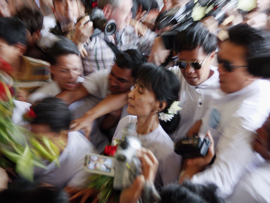 April 2, 2012: Myanmar's pro-democracy leader Aung San Suu Kyi makes her way through the crowd as she arrives to the office of her National League for Democracy (NLD) in Yangon. Aung San Suu Kyi won a seat in parliament on Sunday, her party said, after an