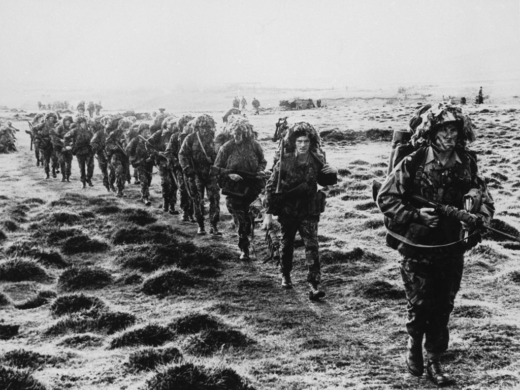 A line of British soldiers in camouflage advancing during the Falklands War