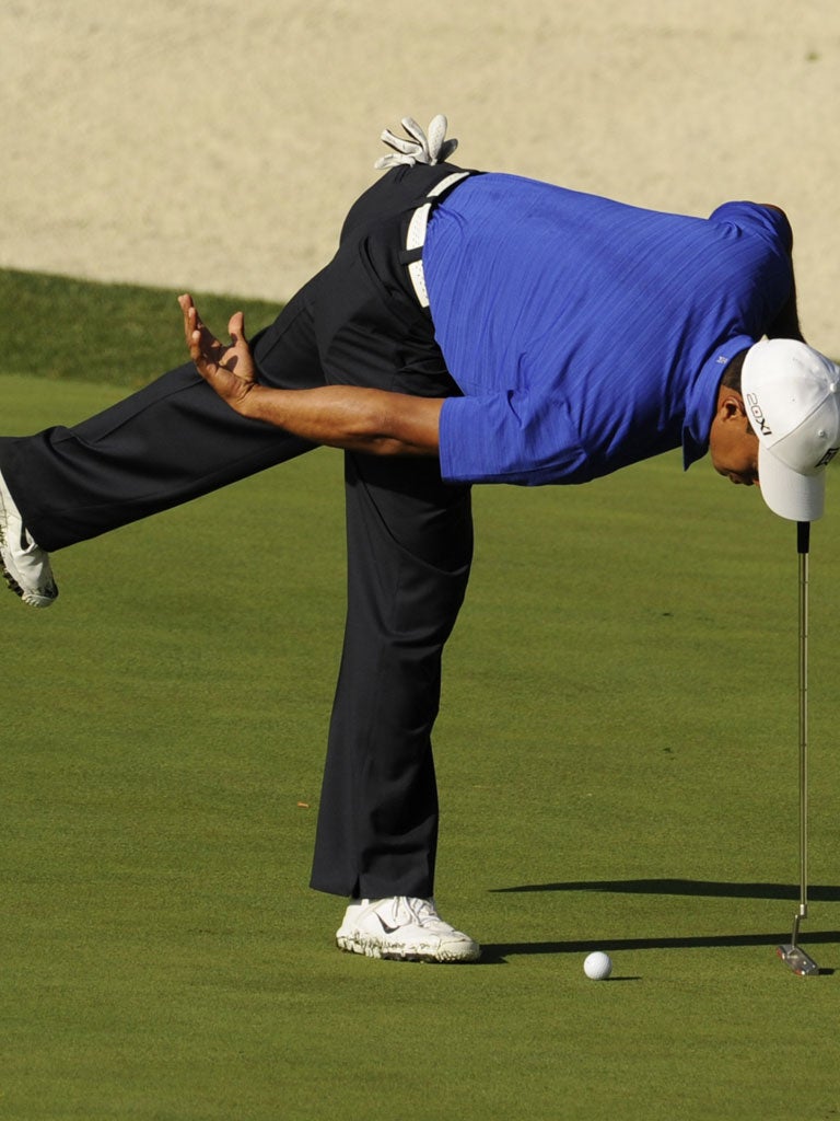 Tiger Woods inspects his ball during a practice round at Augusta yesterday