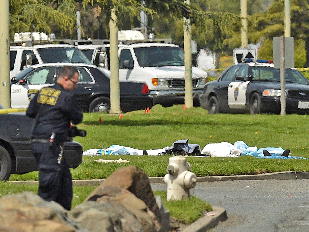 Dead bodies lie covered on the grass near Oikos University in Oakland