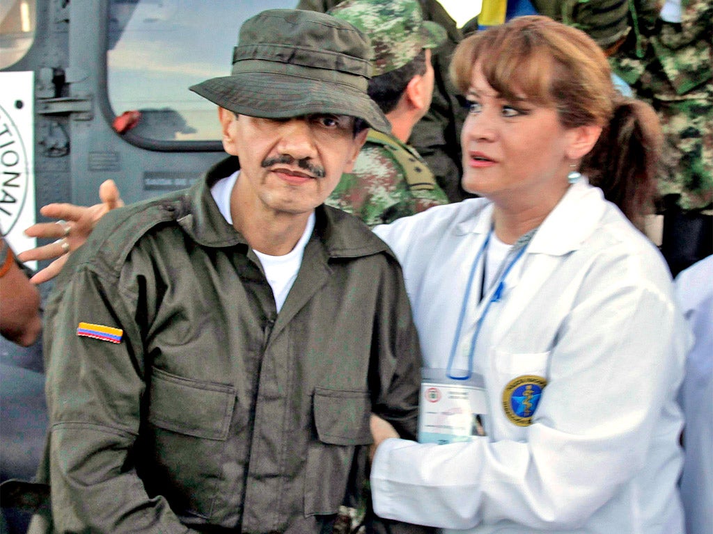 A freed captive, Jorge Romero, is helped by a doctor at the airport