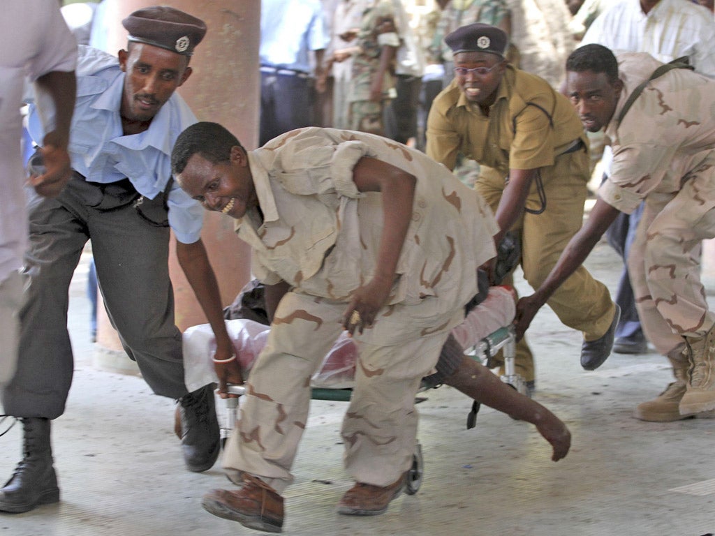 Soldiers carry the body of the chairman of Somali football federation Said Mugabe