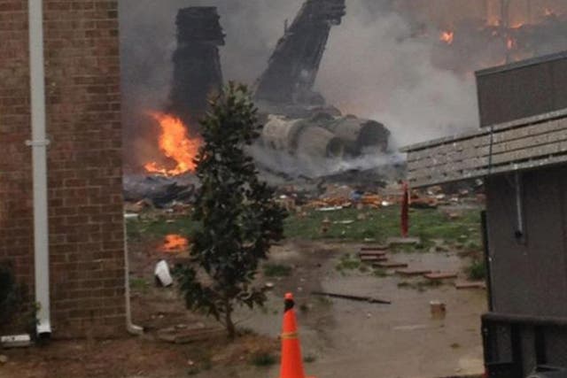 The burning fuselage of an F/A-18 Hornet lies smoldering after crashing into a residential building in Virginia Beach