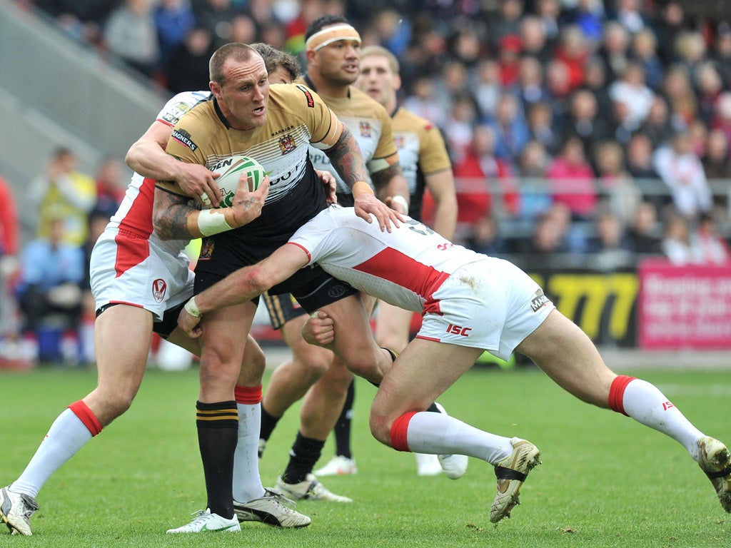 Gareth Hock, of Wigan, is shackled by the St Helens defence at
Langtree Park