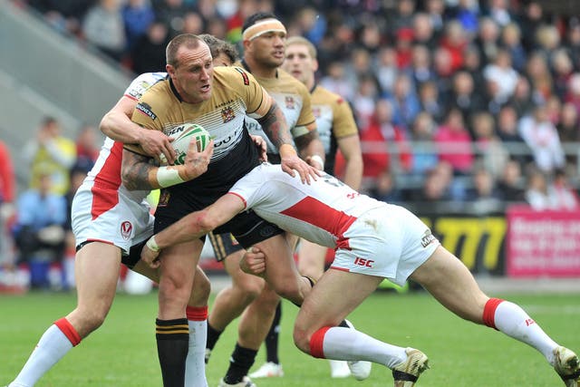 Gareth Hock, of Wigan, is shackled by the St Helens defence at
Langtree Park
