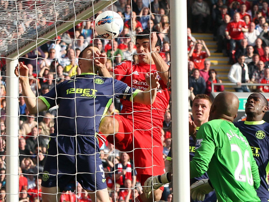 Luis Suarez beats Wigan defender Gary Caldwell to score, only for his attempt to be disallowed