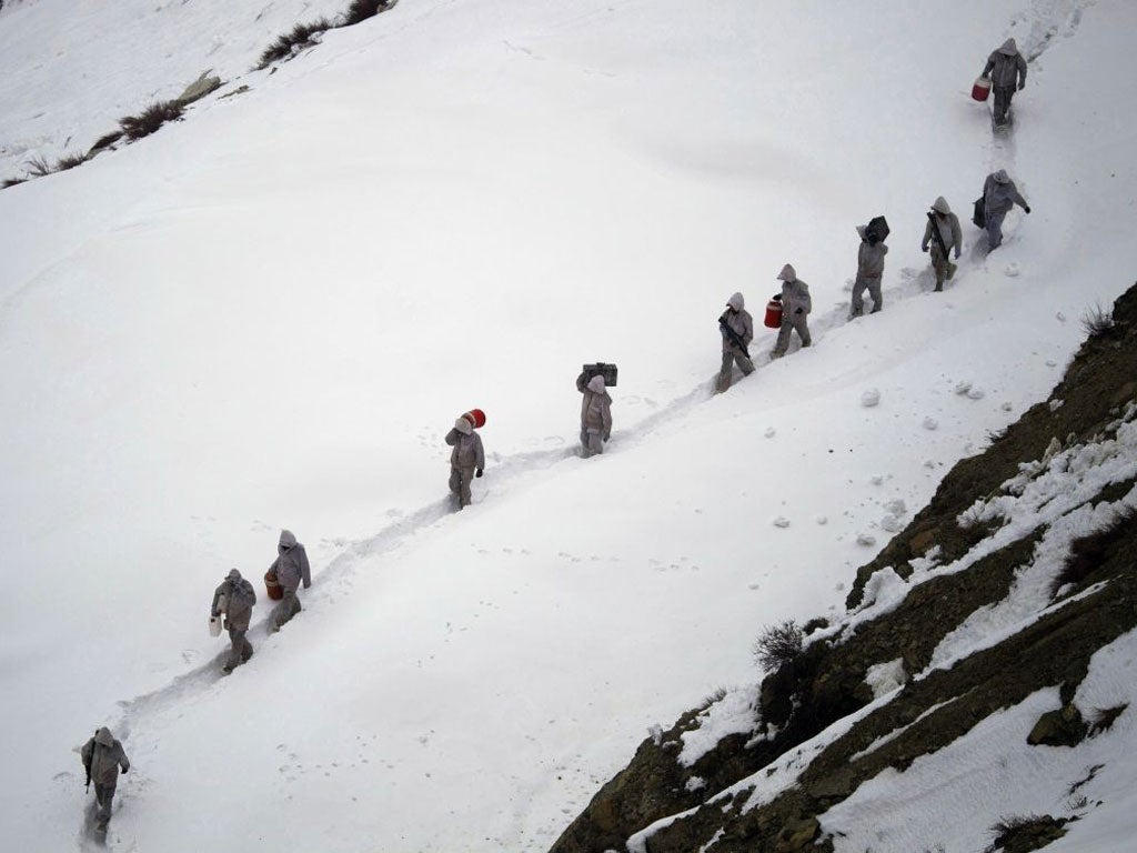 Pakistani soldiers carry supplies down the glacier, near the disaster site