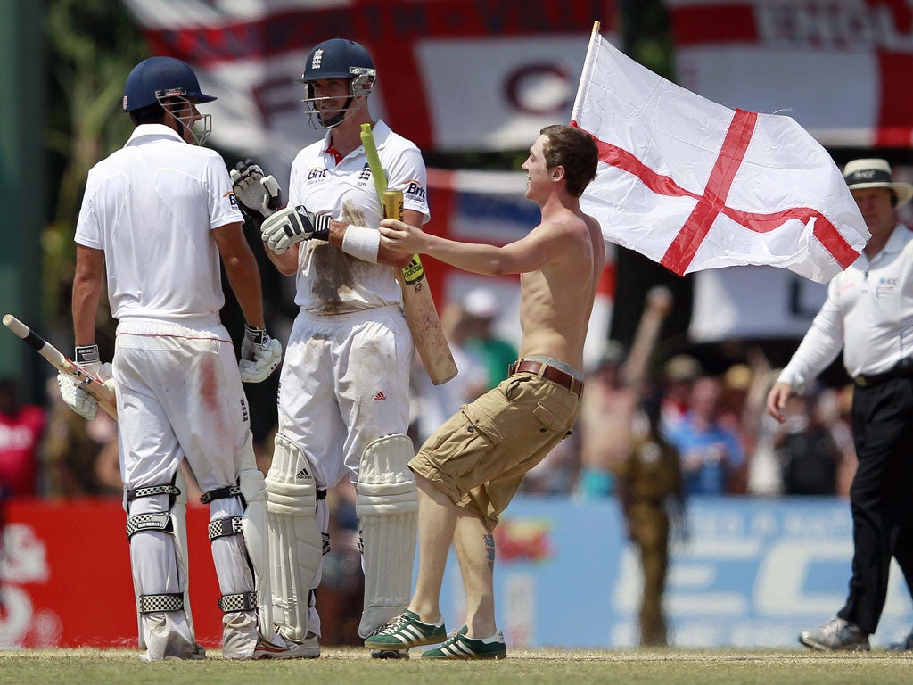 Flying the flag: A happy England fan joins in the celebrations with Kevin Pietersen and Alastair Cook