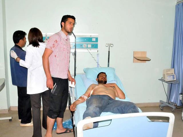 A Syrian refugee, wounded in shootings along the border between Syria and Turkey, lies in a hospital bed