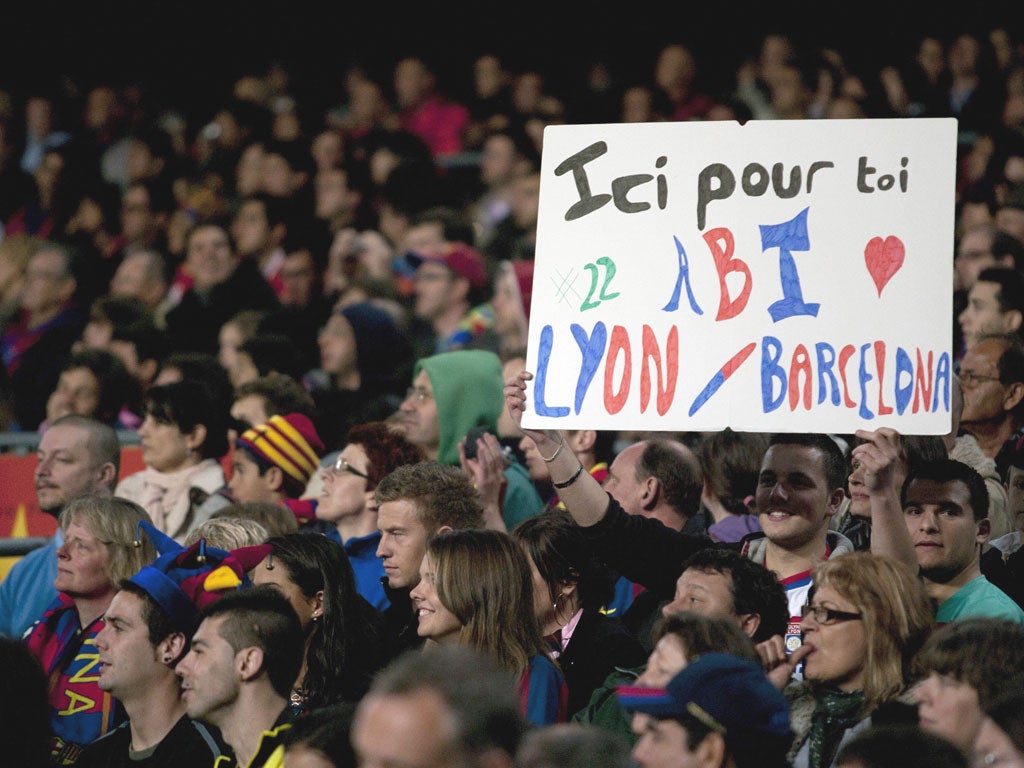 Barcelona fans hold a placard with a message of support for Eric Abidal, during their La Liga match against Getafe at the Camp Nou